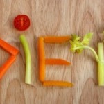 The word diet spelled out in vegetables on a wooden board.