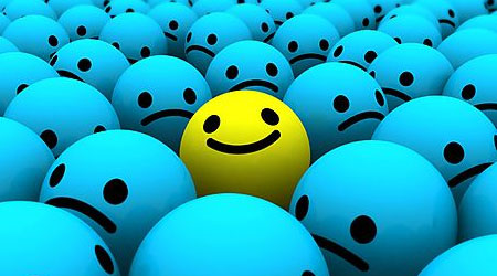 be different be happy yellow smiley in middle of sad blue smileys