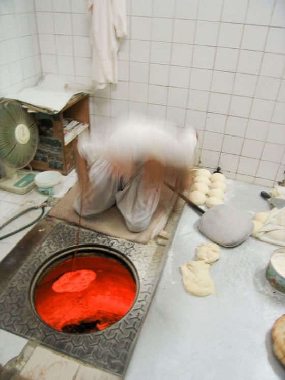 Pakistani Man Cooking Roti In A Red-Hot Tandoor Pakistani Man Cooking Roti In A Red-Hot Tandoor