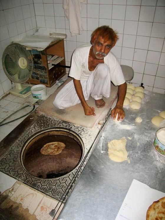 Pakistani Man Cooking Roti In A Tandoor  Pakistani Man Cooking Roti In A Tandoor