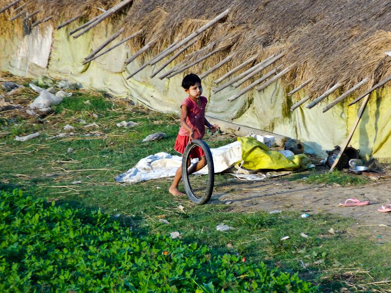 Little Girl Rolling A Tire